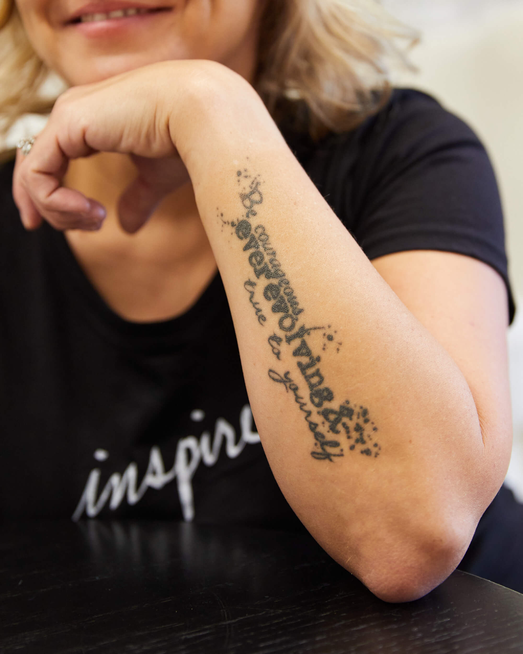 A close-up image of the tattoo on Michelle's arm which says "be courageous, ever evolving and true to yourself".